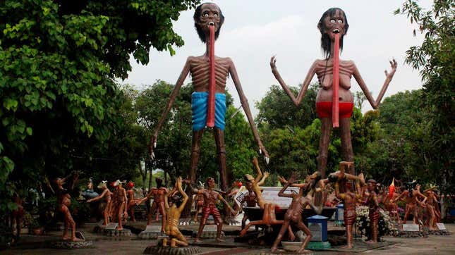 two grotesque and emaciated figures with tongues extending past their torsos loom over various wood-carved figures looking up at them
