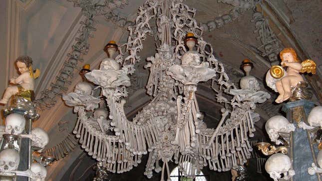 a chandelier made of bones with skulls as accents; angels sit nearby as decoration