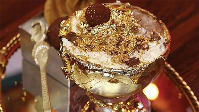 A gold-flecked ice cream sundae in a crystal goblet under warm, ornate lighting